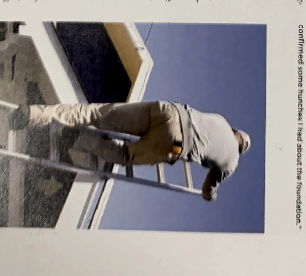 A cropped textbook photo showing an inspector working from a ladder at an exterior wall.