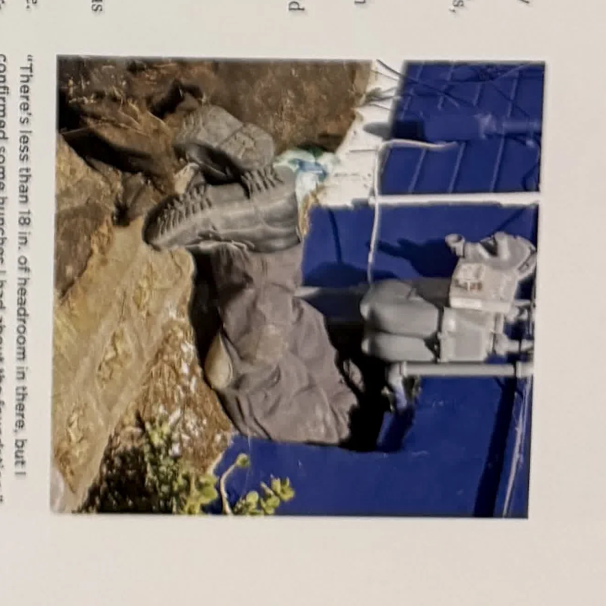 A cropped textbook photo showing workers near an exterior excavation or utility area.