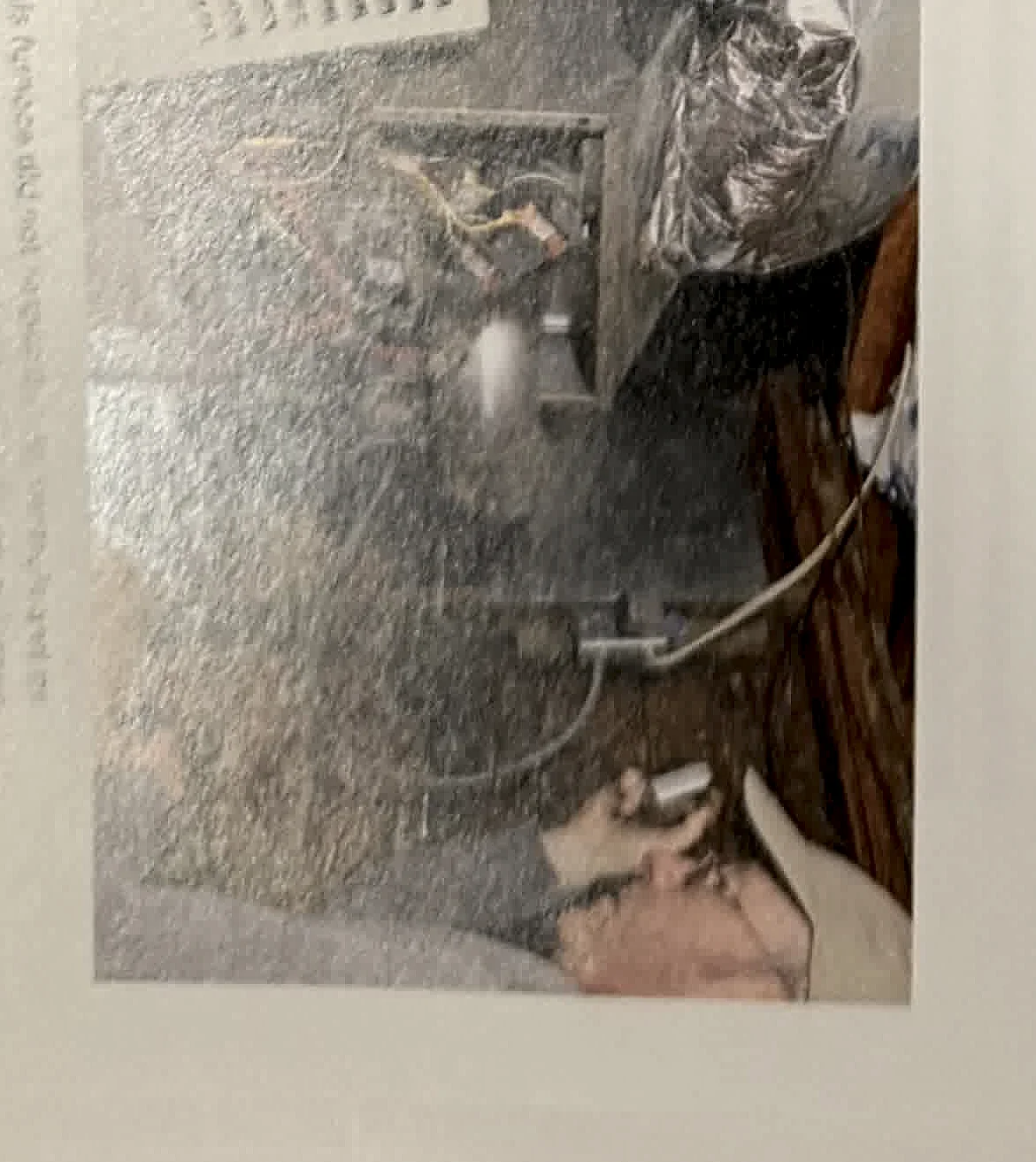 A cropped textbook photo showing plumbing or utility equipment near an exterior or service area.
