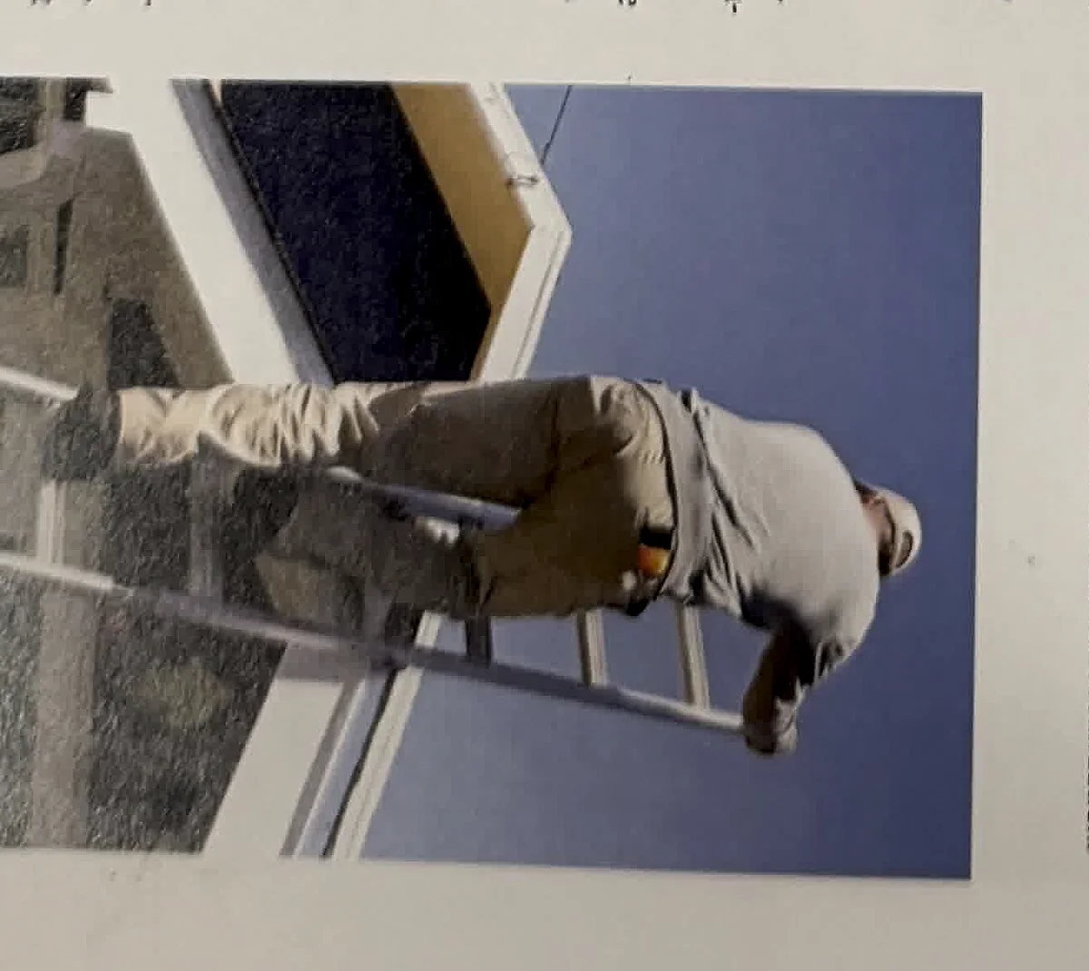A cropped textbook photo showing ladder use at an exterior wall.